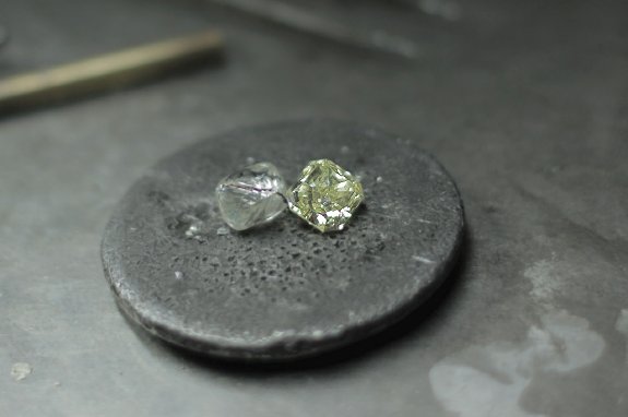 Ein Rohdiamant neben einem polierten Diamant